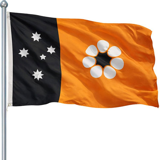 Adopted after self governance was granted on July 1st 1978, this flag consists of the Territorian colours of red, white and ochre. The Southern Cross appears as five white panels stars on a black panel at the hoist, while ochre fills the remainder of the flag. Set on the ochre backdrop in the fly is a Sturts Desert rose www.defenceqstore.com.au