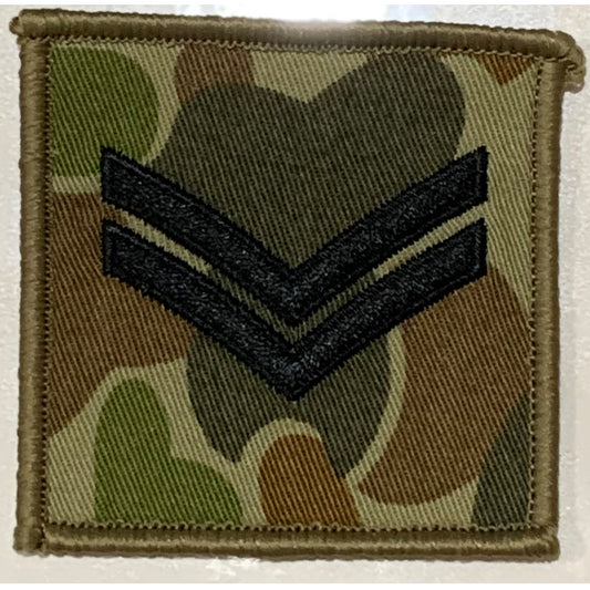 DPCU Rank Patch Corporal Auscam  Corporals are the first rank above Lance Corporal, these soldiers are experienced in their field of skill and have been targeted for leadership capabilities.  These soldiers have had the training and are in the more experienced field of leadership.  Usually they are in command of a section of soldiers.  Size: 6.5cm x 6.5cm  Available with plain or velcro backing