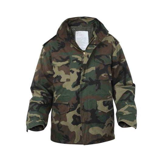 The M65 Field Jacket Parker in Woodland Camo delivers authentic military heritage with practical, everyday versatility. Built from heavy-weight poly/cotton, this hard-wearing jacket withstands harsh conditions while the removable polyester liner adapts to any season — spring through winter. The concealed hood tucks away when not needed, and the brass hardware with storm flap keeps you protected in unpredictable weather. www.defenceqstore.com.au