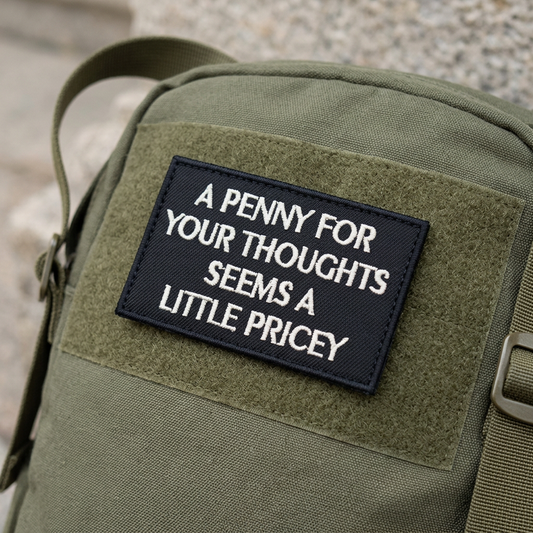 A Penny For Your Thoughts patch mock-up on an olive backpack